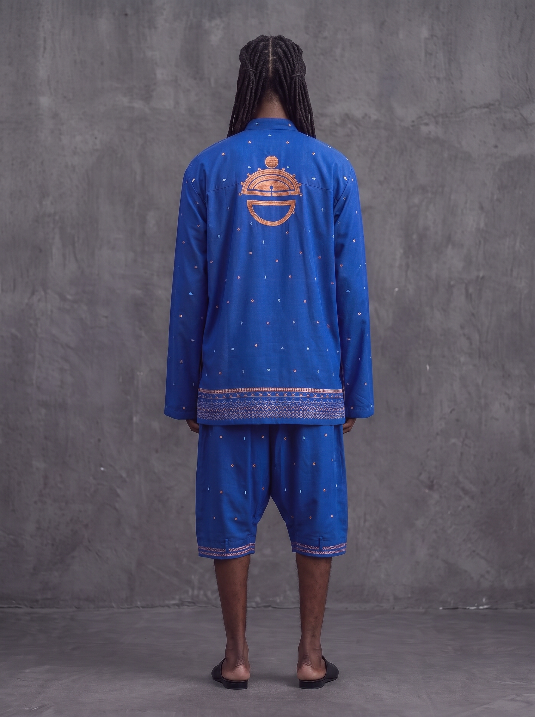 Back view of the cobalt overshirt with copper embroidered emblem and drop crotch pant