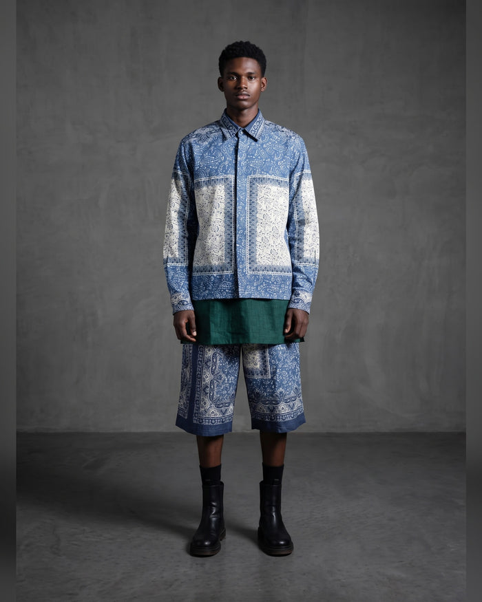 Model wearing the MWAMI paisley print shirt with matching shorts over a green tee, front view